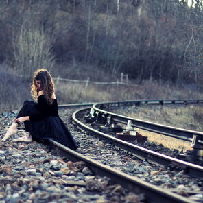 Girl-In-Black-Dress-Sitting-On-Railways-2048x2048