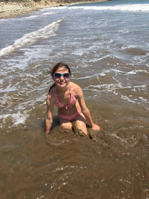 Petite teen playing in the ocean