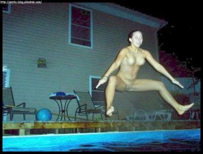 Naked chick jumping in the swimming pool