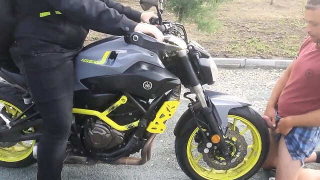 a client gives a massage with his motorcycle until he ejaculates, sperm on the front tire of the motorcycle filmed in Agigea Park on a beautiful Sunday day