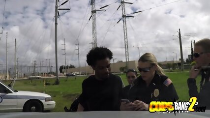 Criminal Is Getting His Black Huge Cock Sucked By Two Slutty Female Cops.
